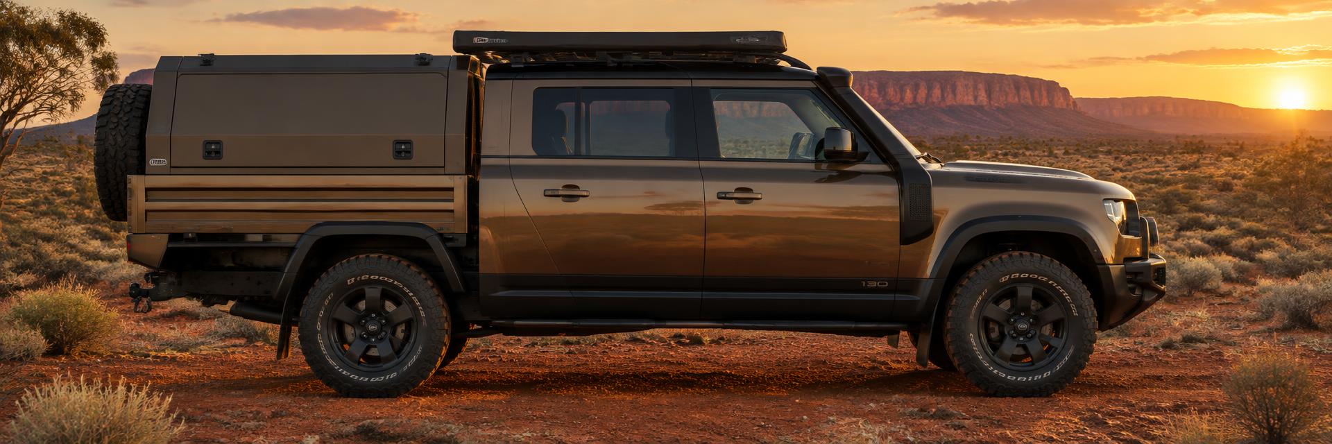 Side profile of a bronze NEW Defender 130-length dual-cab UTE concept in the Australian outback on www.defender-accessories.com